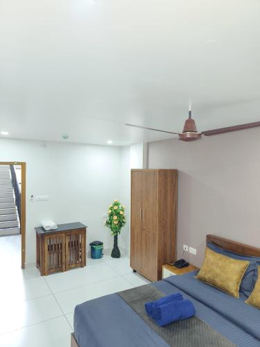 a bedroom with a blue bed and a wooden cabinet at Wayanad Palace in Ambalavayal
