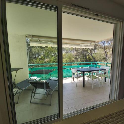 Elle offre une vue sur une terrasse avec une table et des chaises. dans l'établissement Bel appartement de standing à Boulouris, à Saint-Raphaël