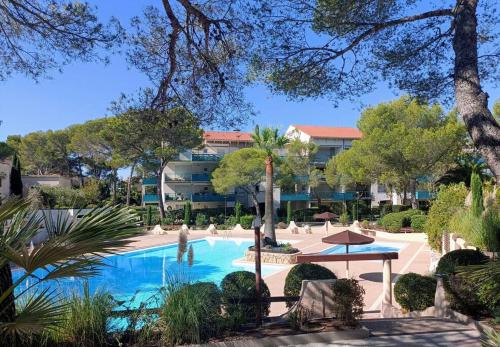 une piscine avec un complexe en arrière-plan dans l'établissement Bel appartement de standing à Boulouris, à Saint-Raphaël