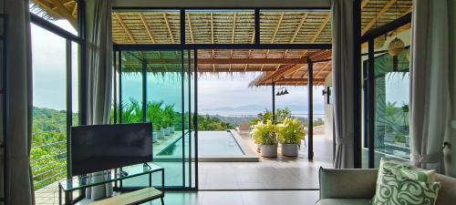 a living room with a view of the ocean from a house at Villa on the Rock - Luxury, Privacy, Pool, Sea View in Koh Phangan in Thong Sala