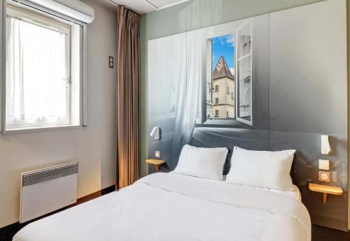 um quarto com uma cama e uma janela em B&B HOTEL Dijon Les Portes du Sud em Dijon