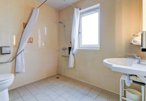 La salle de bains est pourvue de toilettes, d'un lavabo et d'une fenêtre. dans l'établissement B&B HOTEL Dijon Les Portes du Sud, à Dijon