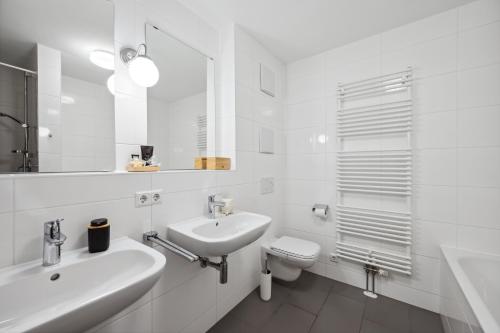 a white bathroom with a sink and a toilet at EXQUIS Design 2BR Apartment BAUHAUS I Balkon I Parkplatz I Top-Lage I Mercedes-Benz I Kinderbetten in Böblingen