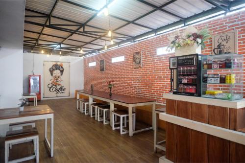 a restaurant with tables and a brick wall at Red Orchid Hotel by Sajiwa in Semarang