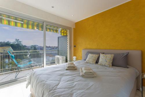 une chambre avec un grand lit et une grande fenêtre dans l'établissement Le Beauséjour by Halldis, à Cannes