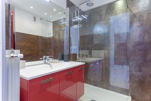 La salle de bains est pourvue d'un lavabo rouge et d'une douche. dans l'établissement Le Beauséjour by Halldis, à Cannes