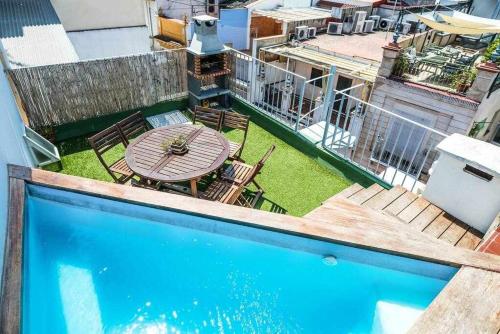 eine Terrasse mit einem Pool, einem Tisch und Stühlen in der Unterkunft Casa con piscina junto catedral de sevilla in Sevilla