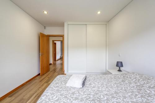 a bedroom with white walls and a large bed at Casa Natalia in Vila Nova de Famalicão