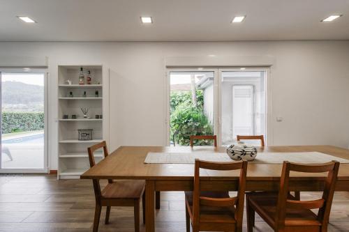 a dining room with a wooden table and chairs at Casa Natalia in Vila Nova de Famalicão