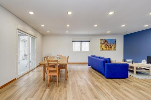 a living room with a blue couch and a table at Casa Natalia in Vila Nova de Famalicão
