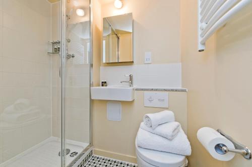 a bathroom with a shower and a toilet and a sink at Vernon House in London