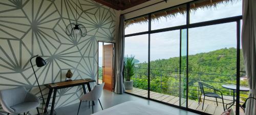a room with a large window and a table and chairs at Villa on the Rock - Luxury, Privacy, Pool, Sea View in Koh Phangan in Thong Sala