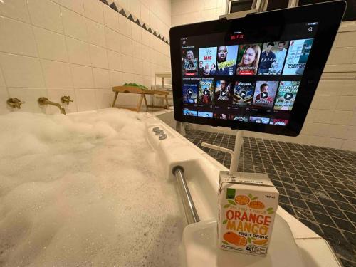 y baño con bañera cubierta de nieve. en Heated toilet seat - Air Conditioning- Hot Tub Spa - Dryer - Electrical BBQ Grill - Pool - Arcade Games at Golden Swan Holiday House, en Sídney