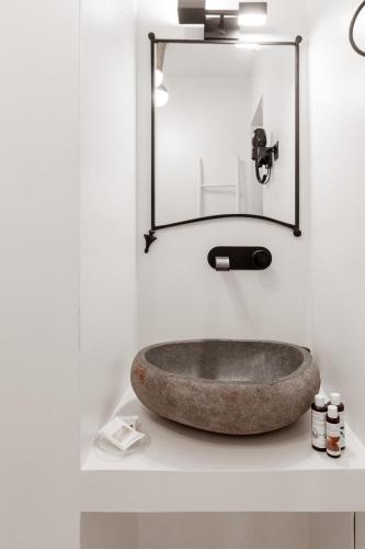 a bathroom with a stone sink and a mirror at Danae Hotel in Nafplio