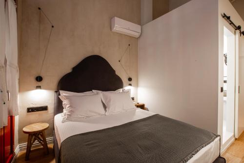 a bedroom with a large bed with a black headboard at Danae Hotel in Nafplio