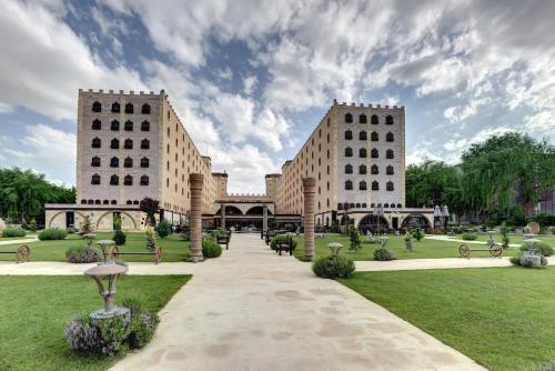 two large buildings with a pathway in a park at Suhan Cappadocia Hotel & Spa in Avanos