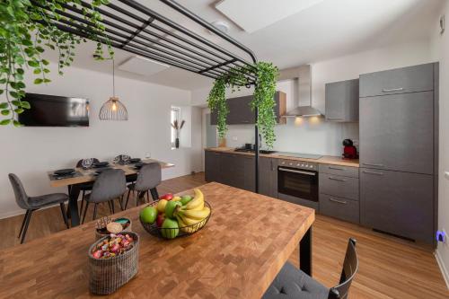 una cocina con una mesa con un bol de fruta. en Apartments Grahek, en Liubliana