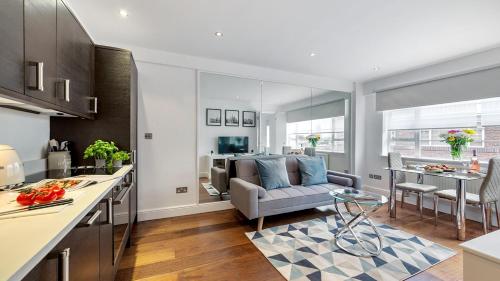 a kitchen and living room with a couch and a table at Nell Gwynn Chelsea Accommodation in London