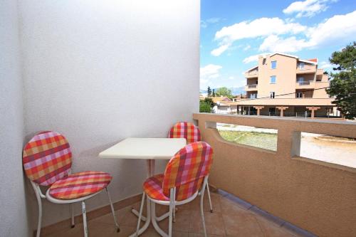 a balcony with a table and chairs and a window at Apartments and Rooms Vesna Novalja in Novalja