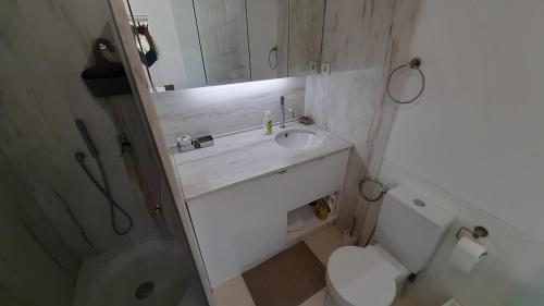uma casa de banho com um lavatório, um WC e um espelho. em Forest View em Lisboa