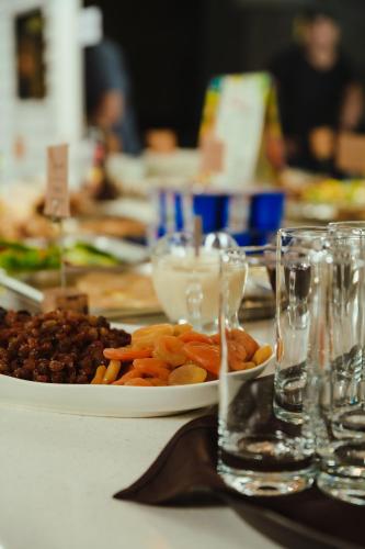 a table with a plate of food and wine glasses at Skif HOTEL & SPA in Petropavlovsk