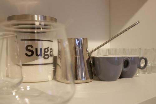 a close up of a glass jar on a counter with cups at Supernova Royal Residence in Novi Sad
