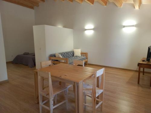 een woonkamer met een houten tafel en een bank bij Cal Vallverdú 2D in Preixana