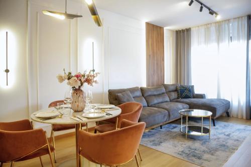 a living room with a couch and a table and chairs at Supernova Royal Residence in Novi Sad
