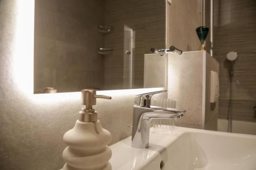 a bathroom sink with a faucet and a mirror at Supernova Royal Residence in Novi Sad