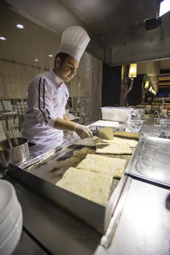 a chef preparing food in a restaurant kitchen at Suhan Cappadocia Hotel & Spa in Avanos