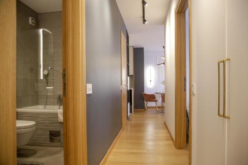 a hallway of a bathroom with a toilet and a sink at Supernova Royal Residence in Novi Sad