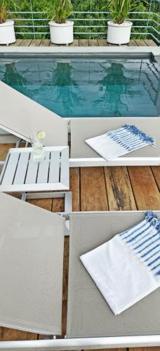 a table and chairs next to a swimming pool at Villa on the Rock - Luxury, Privacy, Pool, Sea View in Koh Phangan in Thong Sala