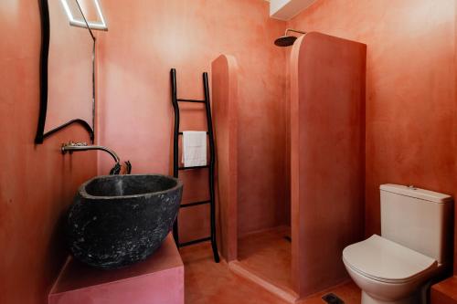 a bathroom with a black bath tub next to a toilet at Danae Hotel in Nafplio