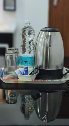 a table with a coffee maker and a bottle of water at Wayanad Palace in Ambalavayal