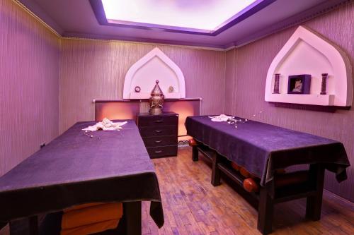 two beds in a room with purple walls at Suhan Cappadocia Hotel & Spa in Avanos