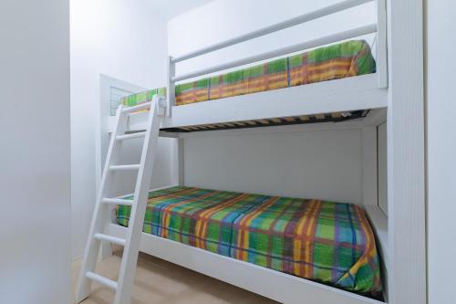two bunk beds with a ladder in a room at Cava Li Santi Residence in Nardò