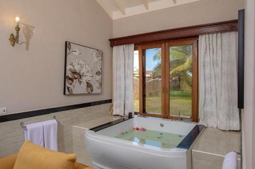 a bathroom with a tub and a large window at Ocean Beach Resort & SPA in Malindi
