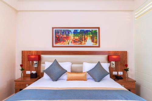 a bedroom with a bed with a painting above it at Pickalbatros Aqua Park Sharm El Sheikh in Sharm El Sheikh