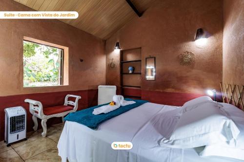 una camera con letto e sedia rossa di Pousada Le Monte Cristo c/ Café Guaramiranga a Guaramiranga