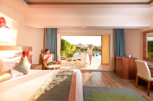 a hotel room with a bed and a living room at Pickalbatros Aqua Park Sharm El Sheikh in Sharm El Sheikh