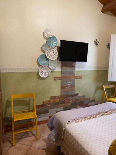 a room with two beds and a flat screen tv on the wall at B&b Torretta San Giovanni a Corte in Sant'Agata de' Goti