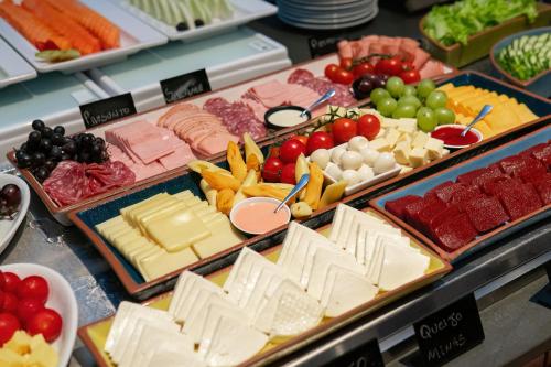 a display of different types of cheese and meats at Novotel Curitiba Batel in Curitiba
