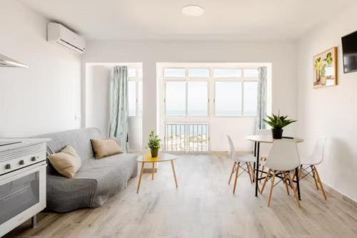 uma sala de estar com um sofá e uma mesa em Blue Sky Apartment em Torremolinos