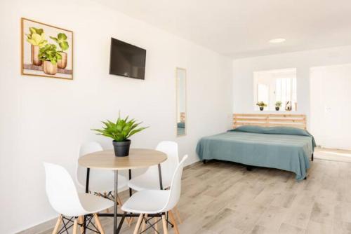 um quarto com uma cama, uma mesa e cadeiras em Blue Sky Apartment em Torremolinos