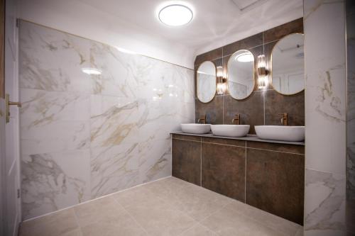 a bathroom with two sinks and two mirrors at Best Western Brome Grange Hotel in Brome