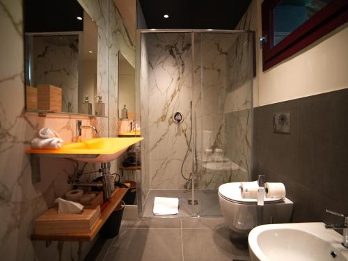 een badkamer met een douche, een wastafel en een toilet bij Foresteria Castello di Perno in Monforte dʼAlba