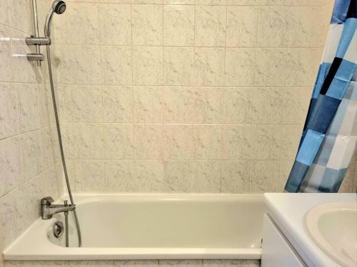 a bathroom with a white tub and a sink at Appartement front populaire stade de france in Saint-Denis