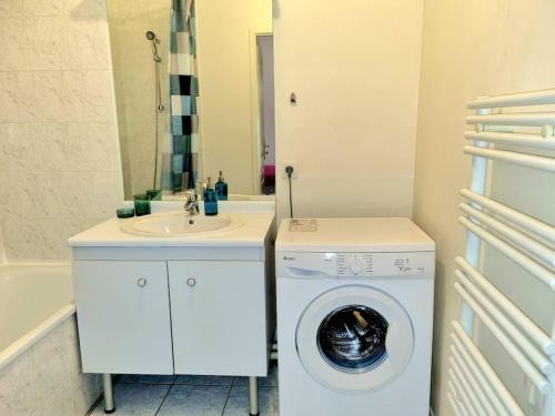 a bathroom with a washing machine and a sink at Appartement front populaire stade de france in Saint-Denis