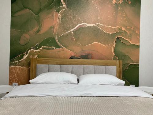 una camera da letto con un letto e un dipinto sul muro di Dream town Apartaments біля залізничного вокзалу a Luc'k