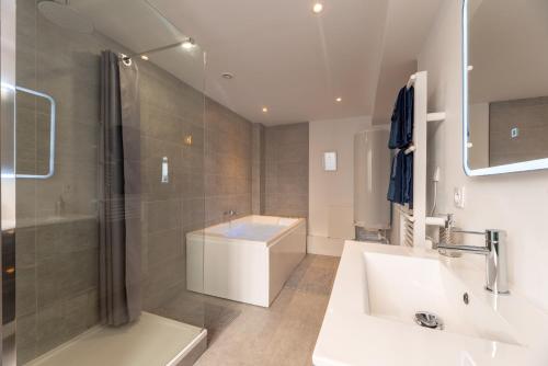 La salle de bains est pourvue d'un lavabo, d'une douche et d'une baignoire. dans l'établissement Le Lovely cosy jacuzzi centre-ville wifi, à Rouen